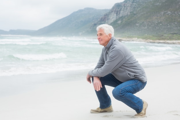 Vista laterale di un uomo anziano rilassante in spiaggia