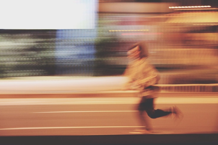Foto vista laterale di un uomo che corre per strada