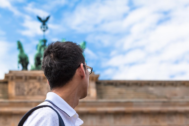 Foto vista laterale di un uomo che guarda lontano contro il cielo in città