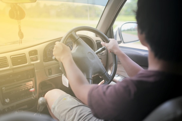 Vista laterale di un uomo che guida un'auto
