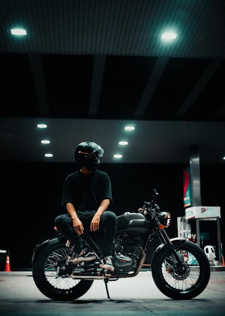 Vista laterale di un uomo che guida uno scooter in strada di notte