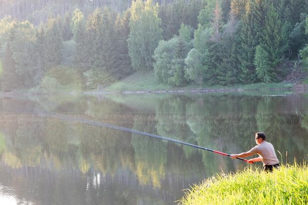 Vista laterale di un uomo che pesca nel lago