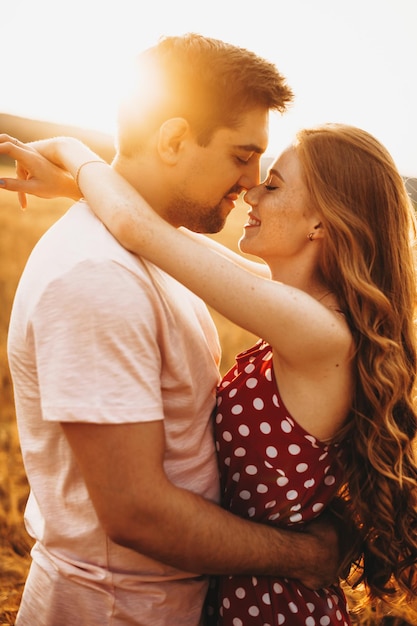 Vista laterale di una coppia che si sorridono in una giornata di sole uomo e donna in estate in un campo di grano