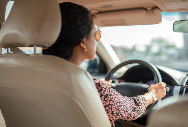 Vista laterale di una donna asiatica alla guida di un'auto