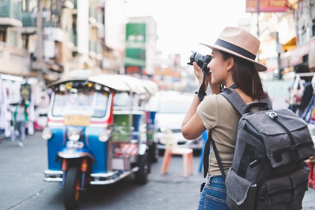 Vista laterale di una donna che fotografa per strada in città