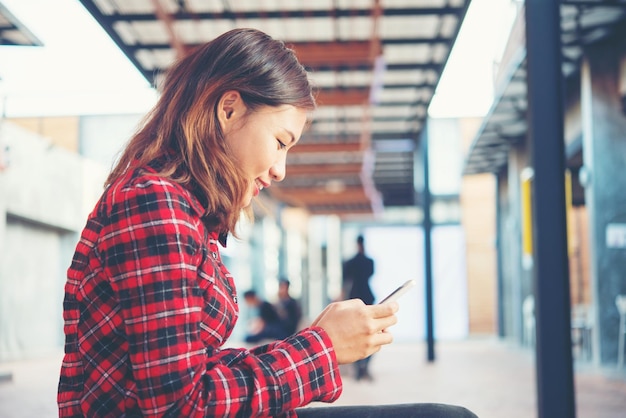 Vista laterale di una giovane donna che usa un telefono cellulare