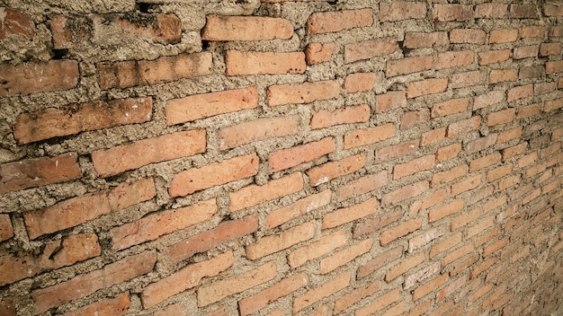 Vista laterale di vecchia priorità bassa arancione dell&#39;annata del muro di mattoni