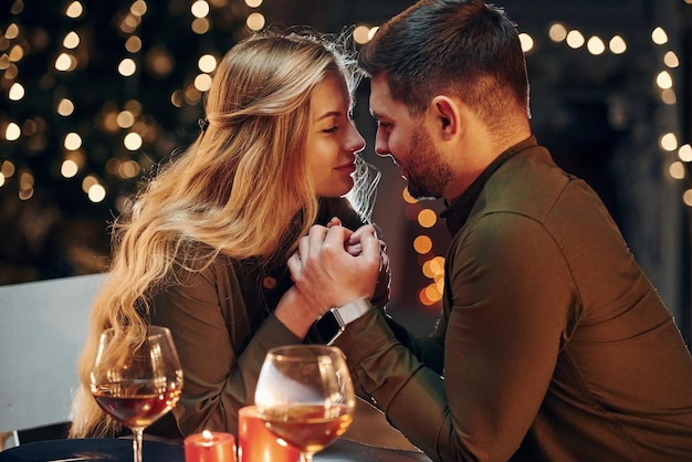 Vista laterale La giovane coppia adorabile ha una cena romantica al chiuso insieme