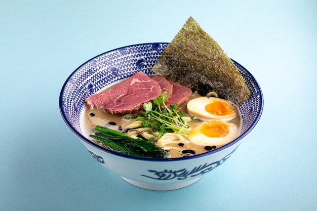 Vista laterale su tori paitan ramen noodle zuppa spessa con pastrami e uova