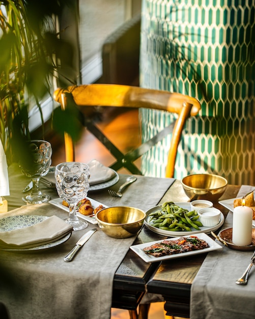 Vista laterale sul tavolo del ristorante servito con antipasti di cucina fusion europea