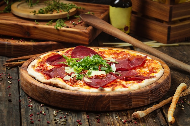 Vista laterale sulla pizza con prosciutto e rucola