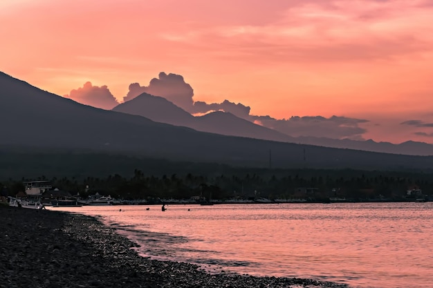 Vista mozzafiato del tramonto sul vulcano Agung dalla spiaggia di Amed a Bali, Indonesia