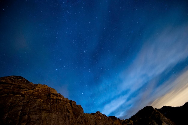 Vista notturna con stelle e cielo blu sulle montagne