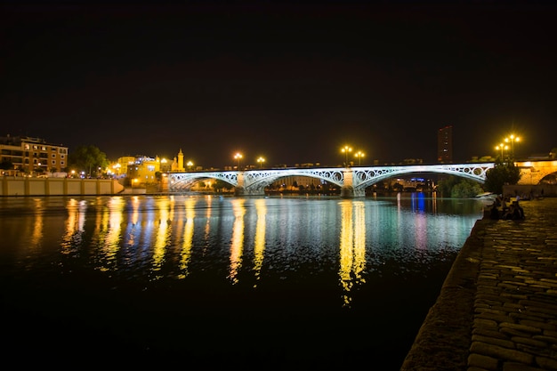 Vista notturna del ponte di Triana a Siviglia Spagna Chiamato anche ponte Isabel II