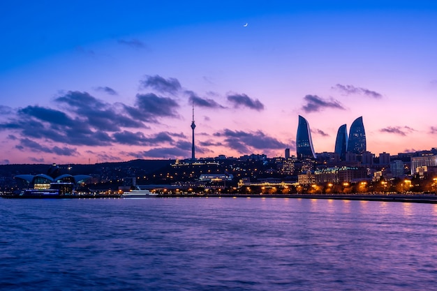 Vista notturna di Baku con i grattacieli Flame Towers, la torre della televisione e il mare del Mar Caspio