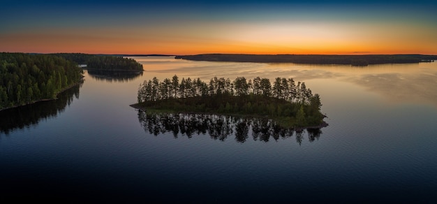Vista panoramica aerea del lago Suoyarvi all'alba circondato dalle foreste della Carelia, Russia