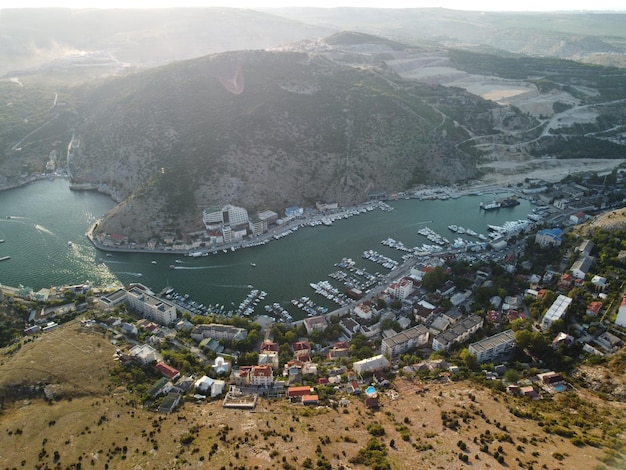 Vista panoramica aerea del paesaggio di Balaklava con barche e mare nella baia della marina all'ora del tramonto Crimea Sebastopoli attrazione turistica Drone vista dall'alto del porto per yacht di lusso barche e barche a vela