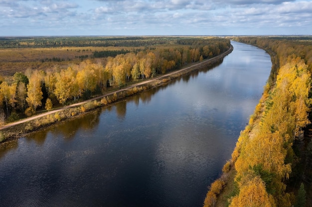 Vista panoramica aerea di un lungo canale che conduce attraverso una foresta in colori autunnali Dubna Russia