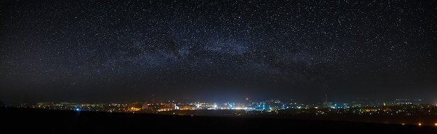 Vista panoramica del cielo notturno stellato sopra la città.