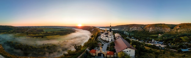 Vista panoramica del drone aereo della Vecchia Orhei al tramonto Valle con fiume e villaggio di nebbia