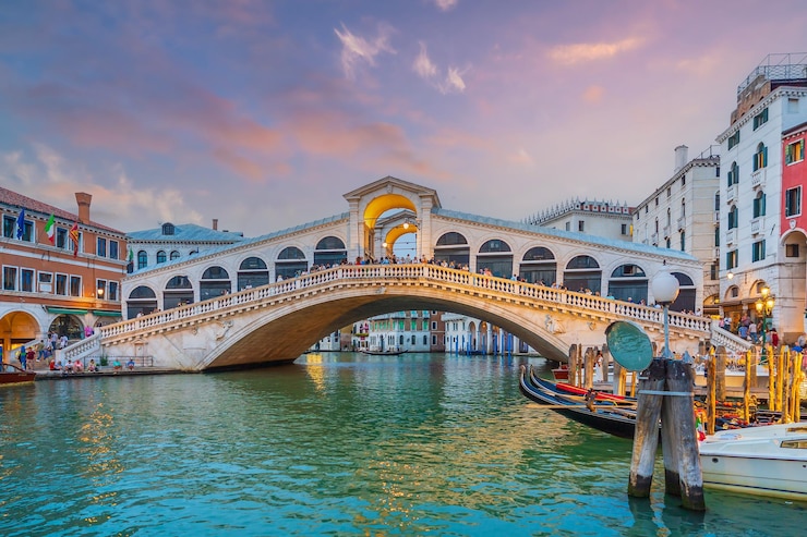 Foto vista panoramica del famoso canal grande con il famoso ponte di rialto al tramonto a venezia