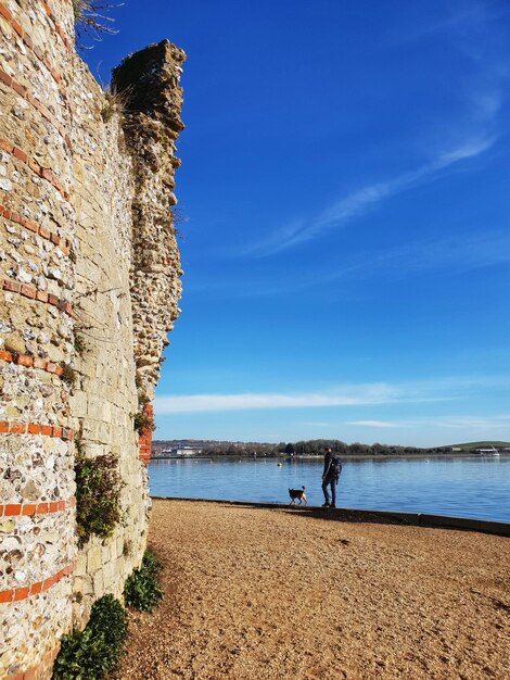 Vista panoramica del mare contro il cielo blu sul bordo del castello con molti e cane