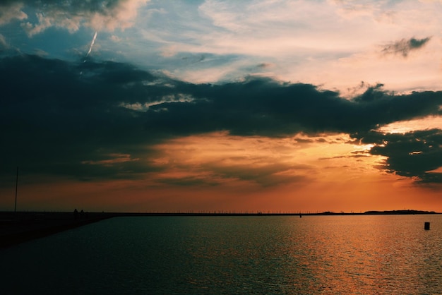 Vista panoramica del mare contro un cielo nuvoloso durante il tramonto
