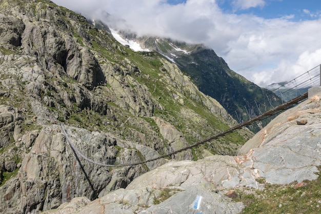 Vista panoramica del ponte Trift nel parco nazionale Svizzera, Europa. Paesaggio estivo, sole, cielo nuvoloso e giornata di sole.