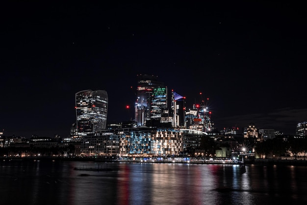 Vista panoramica del quartiere finanziario di Londra con molti grattacieli nel centro di Londra di notte.