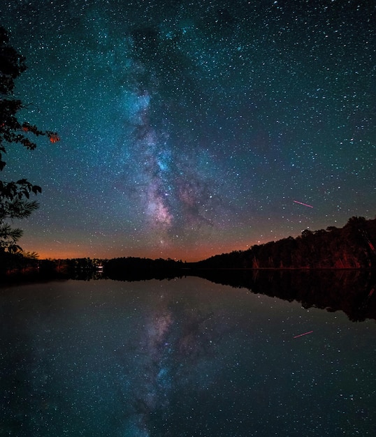 Vista panoramica del riflesso della galassia nel lago contro il cielo notturno