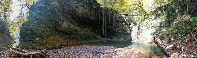 Vista panoramica della cascata nella foresta autunnale. Krasnaya Polyana, Sochi, Russia.