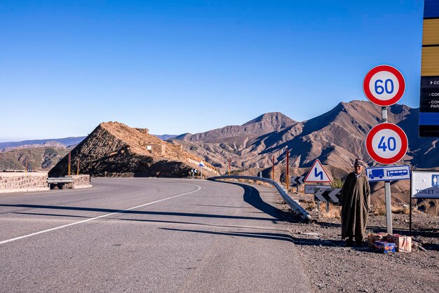 Vista panoramica della catena montuosa arida contro il cielo con l'uomo in attesa del trasporto
