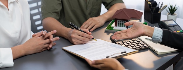 Vista panoramica della coppia sposata che firma il contratto di mutuo per la casa con il broker Prodigy