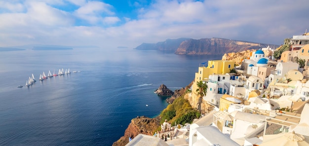 Vista panoramica della famosa isola di Santorini La famosa città di Oia al mattino Una linea di barche a vela in mare Buona vacanza Oia Santorini Grecia