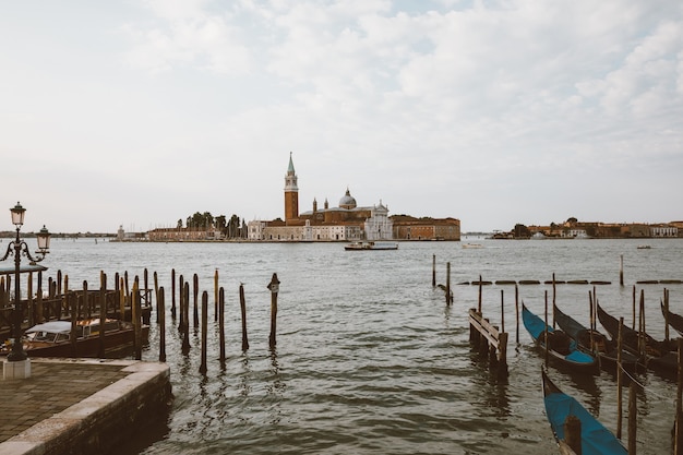 Vista panoramica della Laguna Veneta della città di Venezia con le gondole e l'isola di San Giorgio Maggiore. Paesaggio della mattinata estiva e cielo blu drammatico