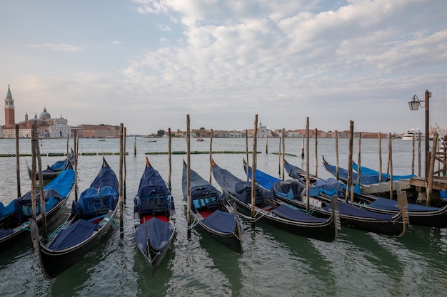 Vista panoramica della Laguna Veneta della città di Venezia con le gondole e l'isola di San Giorgio Maggiore. Paesaggio della mattinata estiva e cielo blu drammatico