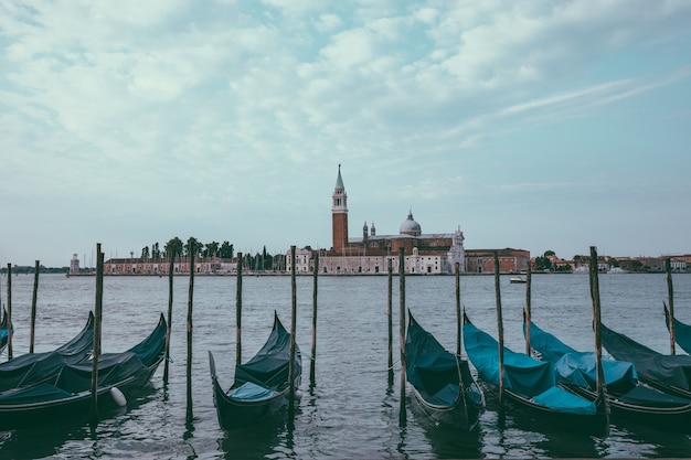 Vista panoramica della Laguna Veneta della città di Venezia con le gondole e l'isola di San Giorgio Maggiore. Paesaggio della mattinata estiva e cielo blu drammatico