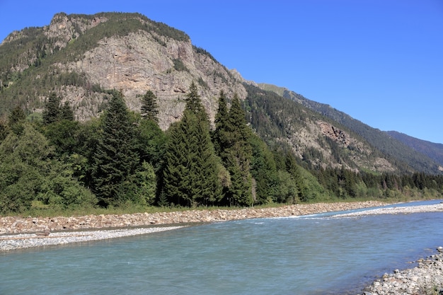 Vista panoramica della scena del fiume nelle montagne del parco nazionale Dombay, Caucaso, Russia, Europa. , Cielo blu drammatico e paesaggio estivo soleggiato