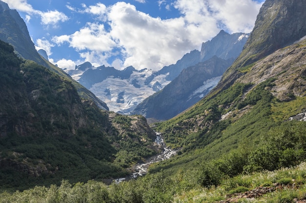 Vista panoramica della scena delle montagne nel parco nazionale di Dombay, Caucaso, Russia. Paesaggio estivo, tempo soleggiato, cielo azzurro drammatico e giornata di sole