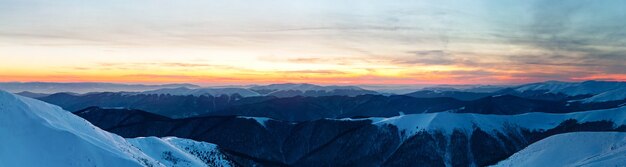 Vista panoramica delle cime delle montagne invernali coperte di neve in una giornata limpida o al tramonto in inverno