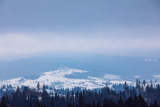 Vista panoramica delle montagne innevate d'inverno. piccolo paese