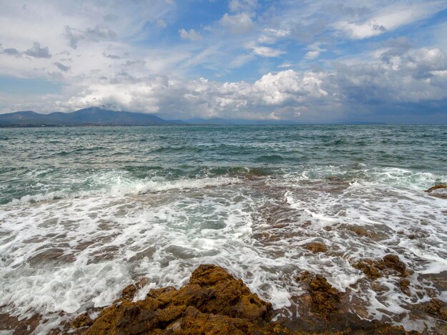 Vista panoramica delle splendide onde delle nuvole temporalesche e della spiaggia rocciosa nel Mar Egeo in Grecia