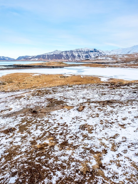 Vista panoramica intorno alla cascata di Kirkjufellfoss nel nord dell'Islanda e lo stagno di ghiaccio scivoloso