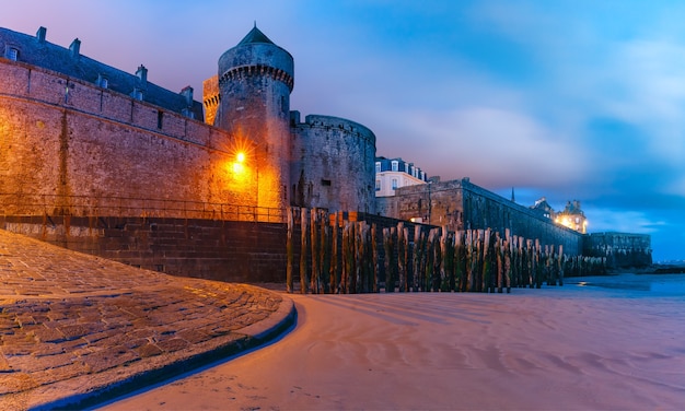 Vista panoramica notturna con la bassa marea della bellissima città murata Intra-Muros a Saint-Malo, conosciuta anche come città corsaire, Bretagna, Francia