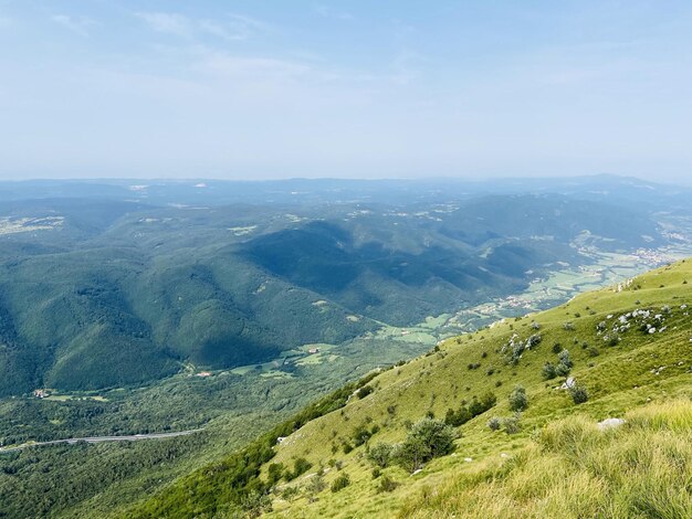 Vista panoramica su splendide colline verdi, montagne, foreste contro il cielo nuvoloso blu. Costa slovena