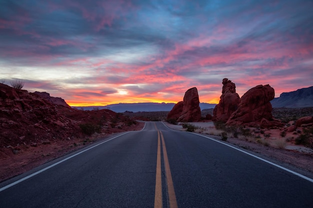 Vista panoramica sulla strada nel deserto durante un'alba drammatica