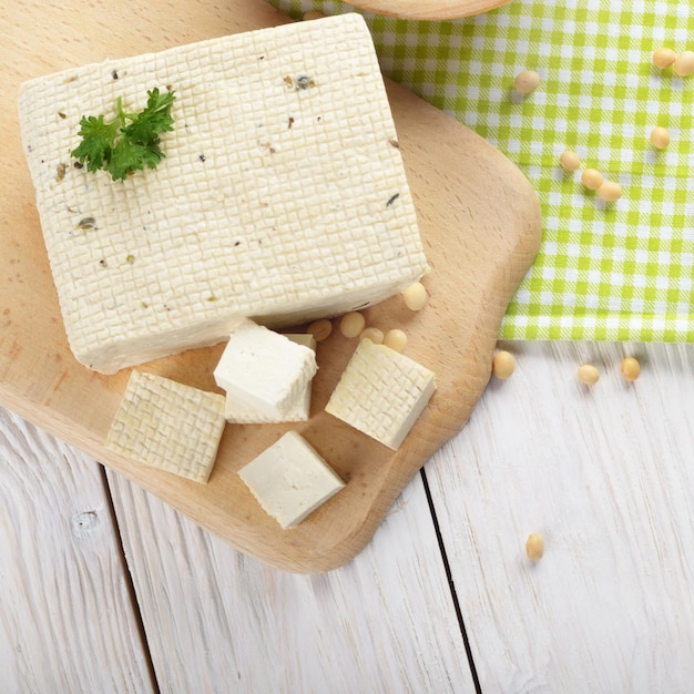 Vista piatta sul tofu di cagliata di fagioli di soia sul tagliere Sostituto alternativo non caseario per il formaggio