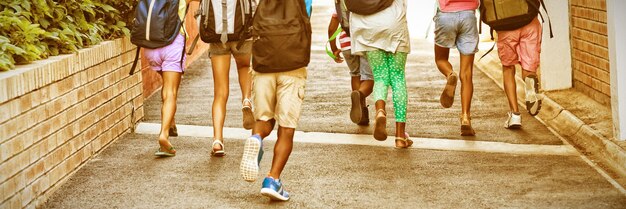 Vista posteriore dei compagni di classe che corrono al campus della scuola