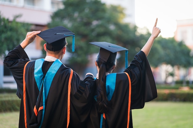 Vista posteriore dei laureati in fila per il premio di laurea nella cerimonia di laurea universitaria. I laureati si stanno radunando alla cerimonia di laurea. Folla dei laureati.