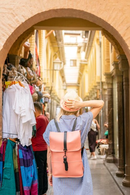 Vista posteriore del backpacker femminile in visita a Granada Spagna camminando attraverso il mercato locale Alcaiceria destinazione paesaggio urbano in AndalusiaVacanze in Europa